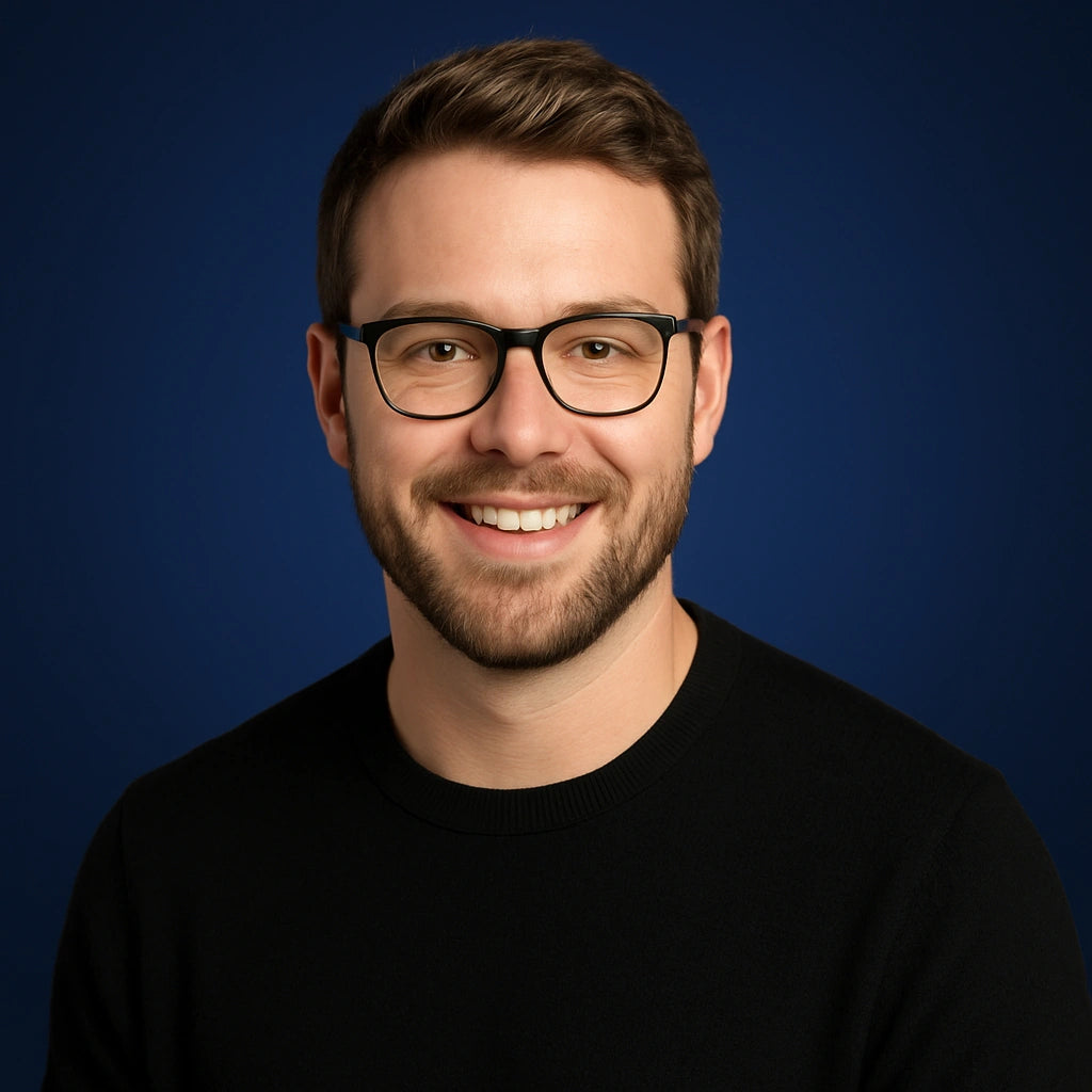 Professional headshot of Jordan Matthews, member of the Story Selection Team at Authority Ink Press, smiling in front of a dark blue studio background.